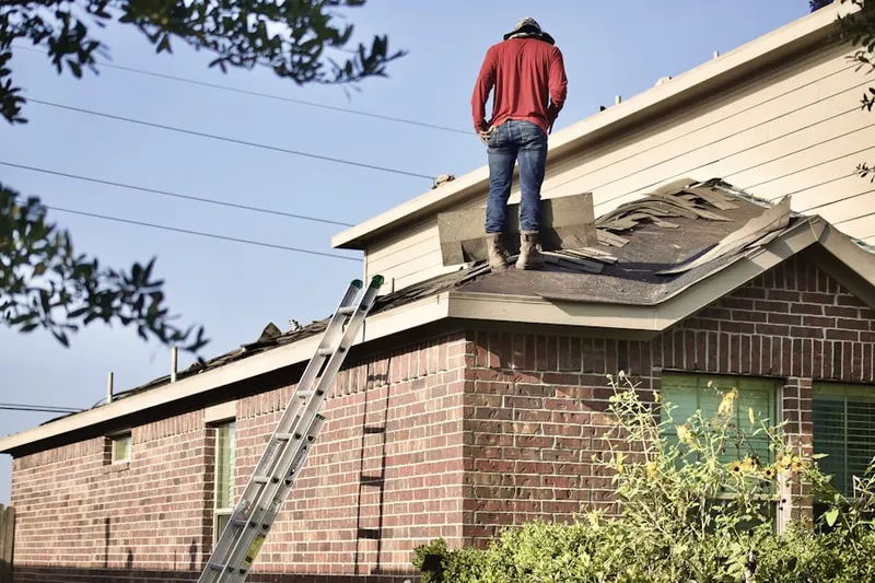 Professional roofer working on a residential roof in Caywood